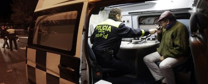 Un conductor sopla en el etilómetro dentro de la furgoneta de la Policía.