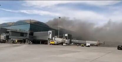 Fotograma del vídeo subido en la cuenta de Twitter @Controladores en el que se aprecia una columna de humo sobre la terminal de pasajeros del aeropuerto de Elche-Alicante.