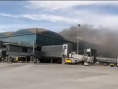 Fotograma del vídeo subido en la cuenta de Twitter @Controladores en el que se aprecia una columna de humo sobre la terminal de pasajeros del aeropuerto de Elche-Alicante.