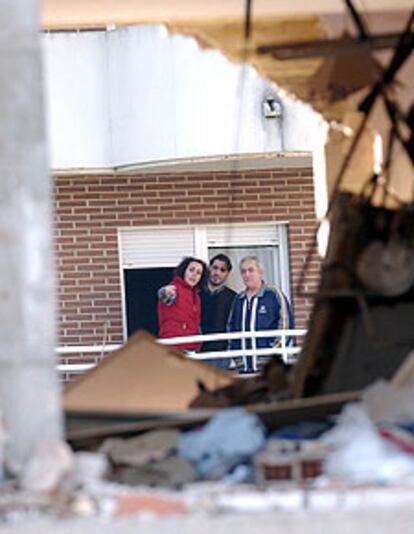 Residentes del edificio de enfrente del bloque en el que se inmolaron los terroristas, retratados desde uno de los pisos destruidos.