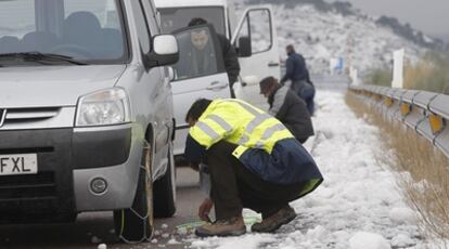 Varios conductores colocan cadenas en la A-23, ayer, a su paso por Viver (Castellón).