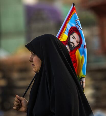 Una mujer con la imagen del imam Husein en Nayaf.