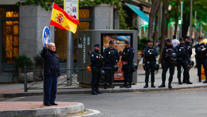Un hombre ondea una bandera española frente a la sede del PSOE, en la calle Ferraz de Madrid, el viernes.