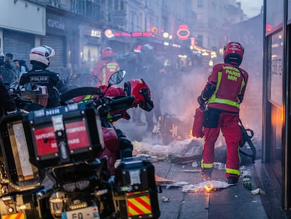 Los bomberos apagan una barricada incendiada durante los disturbios en París.