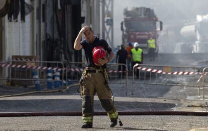 Un bombero sale de la zona afectada por el incendio declarado el s&aacute;bado a mediod&iacute;a en la fabrica de aceite y mayonesa del Grupo Ybarra en Dos Hermanas (Sevilla)