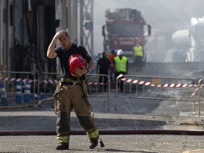Un bombero sale de la zona afectada por el incendio declarado el s&aacute;bado a mediod&iacute;a en la fabrica de aceite y mayonesa del Grupo Ybarra en Dos Hermanas (Sevilla)