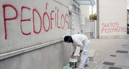 Un pintor cubre una pintada en la parroquia donde ejerc&iacute;a el padre Rom&aacute;n en noviembre de 2014. 