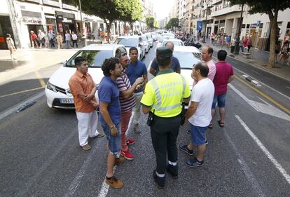 Taxistas de València han parado sus vehículos a última hora de la mañana de en los dos carriles centrales de la calle Colón, en la que se encuentra la sede de la Delegación del Gobierno, como protesta por la proliferación de licencias VTC.