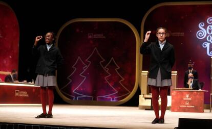 Las niñas del colegio de San Ildefonso Elisabeth Obarisaiagbon (i) Noura Akrouh (d) cantan un quinto premio, que ha recaído en el número 86986.