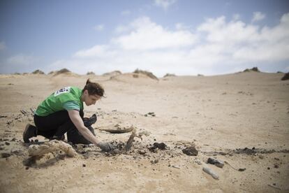 Una voluntaria de la ONG WWF recogen plásticos llegados a través del mar, en la costa de La Graciosa.