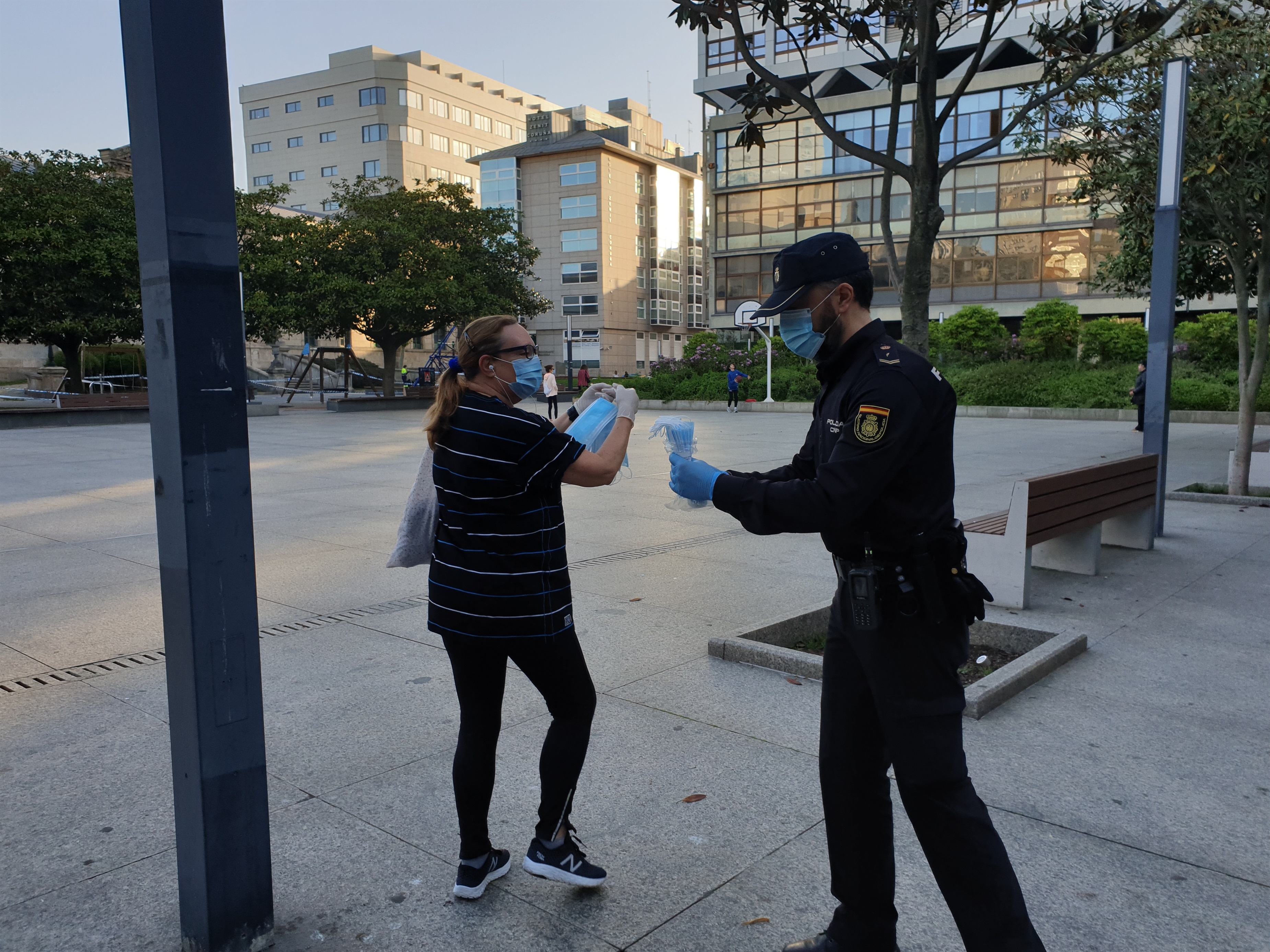 Un agente reparte mascarillas este martes en A Coruña.