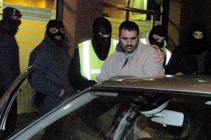 Agentes de la policía y de la Guardia Civil trasladan a uno de los detenidos la madrugada de ayer en Barcelona.