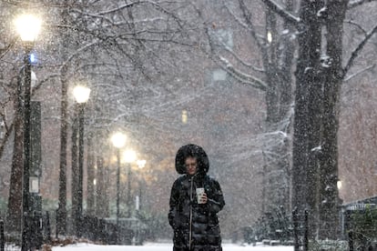 A pedestrian stands as the snow falls during a Nor'easter winter storm in New York City, U.S., February 13, 2024.