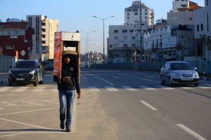 Un vendedor palestino transporta una caja de madera por una calle de la ciudad de Gaza (Franja de Gaza).