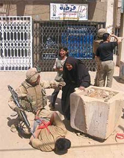 Un <i>marine</i> retiene a un sospechoso de saqueo en Bagdad.