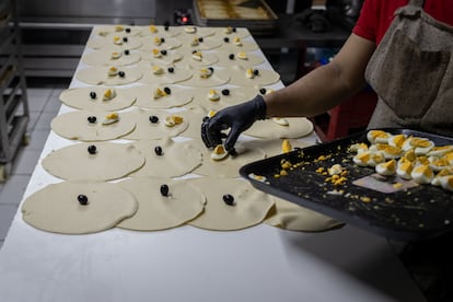 Un trabajador del local 'Empanadas Don Guille' realiza la producción de empanadas de pino.