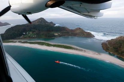 El avión 'Rosalía de Castro-Sasemar 102', con el apoyo por mar de la embarcación 'Salvamar Mirach' (abajo), este jueves durante la búsqueda de sacos de 'pellets' sobre la playa de Rodas, en las islas Cíes. 
