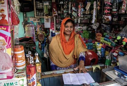 Beneficiaria de una inversión de capital, Subarna Sarka muestra las cuentas de su negocio, una tienda de ultramarinos en la población de Mitapukur, en el norte de Bangladesh.