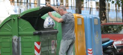 Una persona deposita una bolsa de basura en un contenedor en San Sebastián.