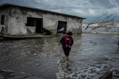 Barbara Cardosa camina junto a las casas destruídas por el mar en la colonia El Bosque, en el Estado de Tabasco, el 18 de noviembre. El aumento del nivel del mar en las costas de esta comunidad ha destruido calles, árboles y casas, forzando a sus pobladores a buscar un nuevo lugar para vivir. 