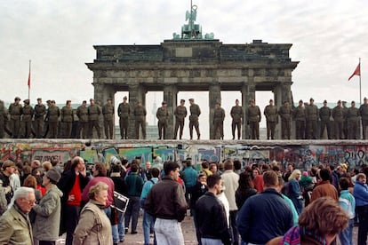 Guarda fronteiriços de Berlim Oriental permanecem sobre o muro em frente ao Portão de Brandeburgo, em Berlim (Alemanha), em 11 de novembro de 1989.