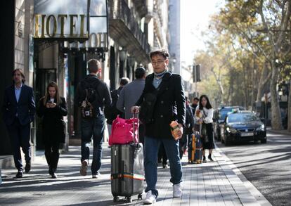 Un turista al costat d'un hotel a la Rambla.