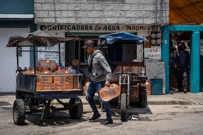 Un joven coloca garrafones de agua purificada en un remolque para repartirlos en Ecatepec (Estado de México), en 2021.