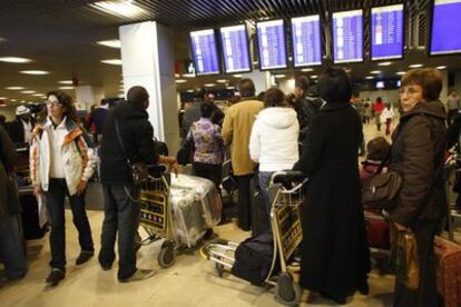 Un grupo de pasajeros observa un panel de información del aeropuerto de Barajas durante la jornada de ayer, en la que se vivieron numerosas demoras a causa de la falta de controladores aéreos. Hoy, sábado, Barajas ha abierto con normalidad.