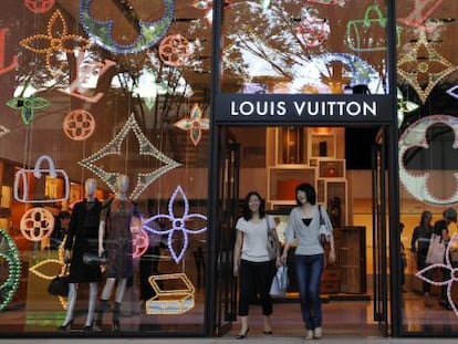 Dos clientas salen de la tienda que la firma Louis Vuitton