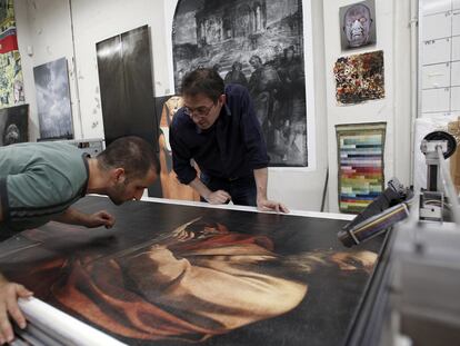 Adam Lowe (a la derecha) y uno de sus colaboradores revisan en el escáner la copia impresa de <i>San Mateo y el ángel,</i> de Caravaggio.