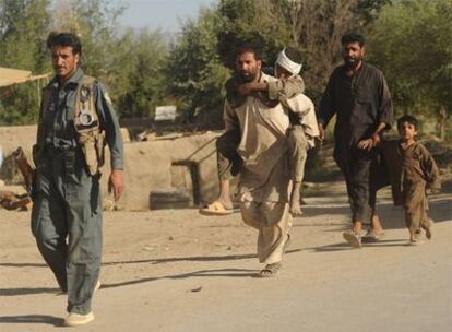 Un hombre lleva a su hijo herido durante el ataque talibán en Pul-i-Alam, capital de Logar.