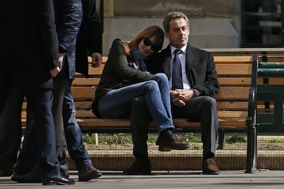 El expresidente Sarkozy y su mujer, Carla Bruni, sentados en un banco tras votar en la primer ronda de las elecciones municipales en París.