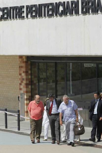 Millet, a la izquierda; el abogado Jordi Pina, con corbata, y Montull, ayer, al salir de prisión.