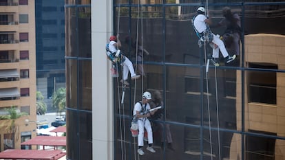 Varios operarios trabajan en altura en el mantenimiento de un edificio en Valencia, el pasado 12 de junio.