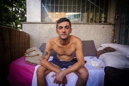 El madrileño Pablo Ruiz, de 41 años, sentado en una cama improvisada en la que duerme a la intemperie en el municipio de Alcorcón, antes de salir a buscar comida en julio.