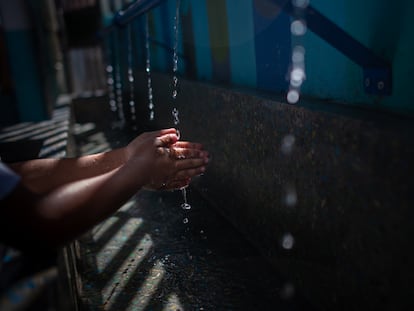 Un niño se lava las manos usando el lavabo del sistema de captación de agua de lluvia Lata de Agua, en el colegio Unidad Educativa Fermin Toro, en Caracas (Venezuela).