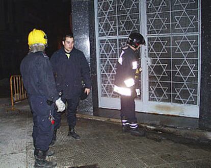 Los bomberos, ante la puerta de la sinagoga de Ceuta, tras sofocar el incendio.