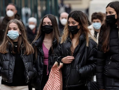 Varias personas caminan por la calle en Valencia con mascarilla.