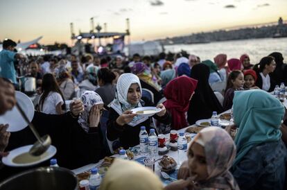 Mulheres turcas recebem uma porção de comida após o entardecer na cidade de Istambul, em 3 de julho de 2014.