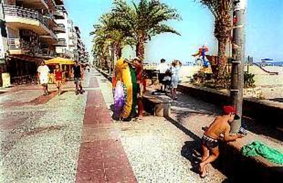 Paseantes y bañistas, en el paseo marítimo de la playa de Calafell.