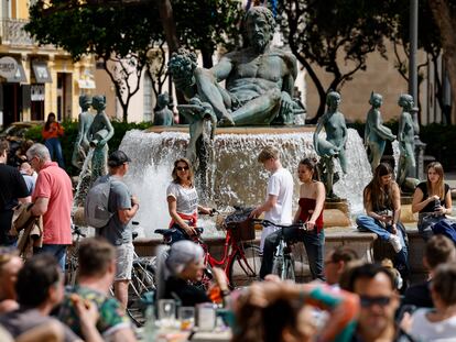 Un grupo de turistas pasea por la céntrica plaza de la Virgen de Valencia este martes, en el que ya se alcanzaron entre 22 y 24 grados en algunas localidades de la Comunidad Valenciana.