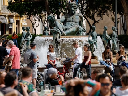 Un grupo de turistas pasea por la céntrica plaza de la Virgen de Valencia este martes, en el que ya se alcanzaron entre 22 y 24 grados en algunas localidades de la Comunidad Valenciana.