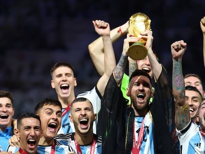 El argentino Lionel Messi levanta el trofeo de la Copa del Mundo junto a sus compañeros de equipo, mientras celebran después de ganar la Copa del Mundo.