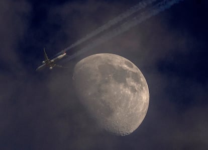 Vista de un avión volando junto a la Luna, desde Fráncfort (Alemania), el miércoles. La aerolínea Ryanair anunció que eliminará la mascarillas obligatorias para evitar contagios de coronavirus en algunos vuelos europeos, si bien las mantendrá en 15 países de la Unión Europea, entre ellos España, en los que la ley obliga a utilizarlas en transportes públicos.