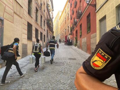 La policía científica acude al domicilio donde se produjo el asesinato a cuchilladas de una mujer en Madrid.