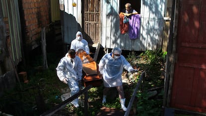 Empleados municipales recogen el cadáver de una nonagenaria fallecida por complicaciones de la covid en su casa de Manaos.