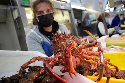 Una trabajadora del mercado de San Agustín, en A Coruña, muestra una centolla.