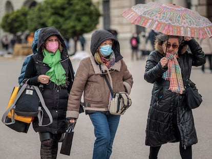 Varias personas pasean abrigadas por el centro de Valencia este lunes a causa de las temperaturas inusualmente bajas.