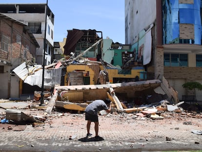 Un hombre saca una fotografía de un edificio derrumbado en Machala (Ecuador), este sábado.