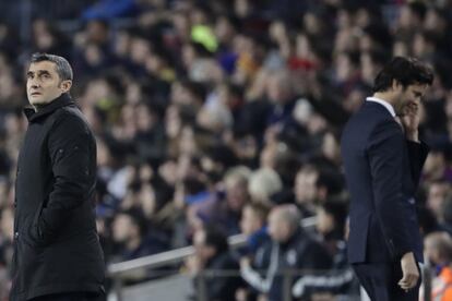 El entrenador del Barcelona, Ernesto Valverde, mira la pantalla mientras el entrenador del Real Madrid, Santiago Solari, vuelve a la bancada.